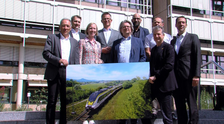 Die Projektbeteiligten halten vor dem Landratsamt ein Bild der Zollern-Alb-Bahn hoch (Quelle: RTF.3)
